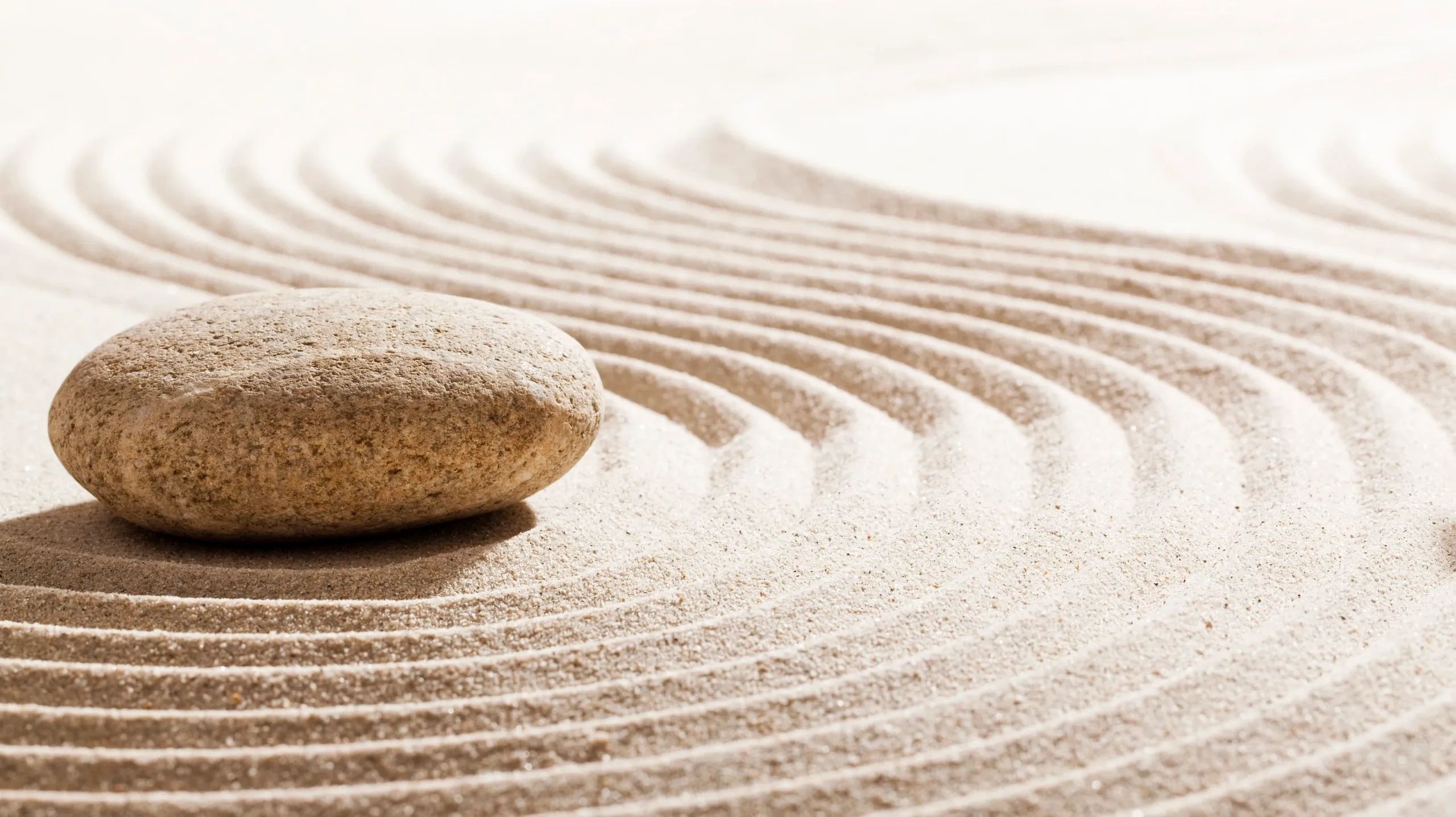 A single pebble resting on raked sand